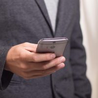 鲁大师、 一位穿深色衬衫的男性坐在工作台前，手里拿着游标卡尺测量散热器，桌上散放螺丝与导热硅脂，暖色台灯照出专注神情